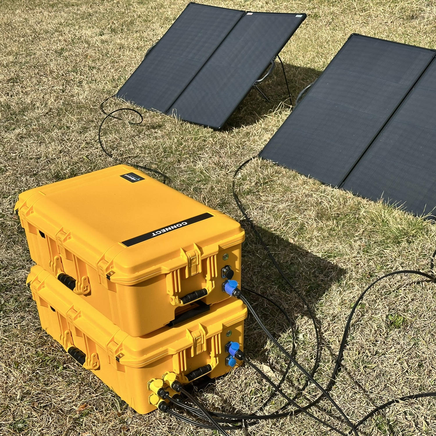 Yellow portable power station with solar panels on a grassy surface